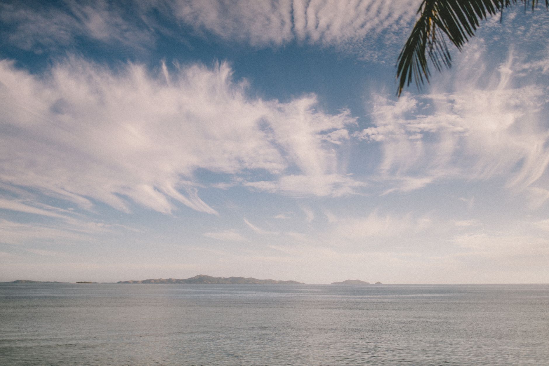 Palm-fringed white sand beach and turquoise lagoon in Fiji